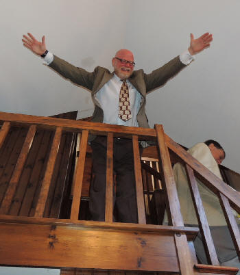 Jeff Barnhart at top of staircase, arms outstretched