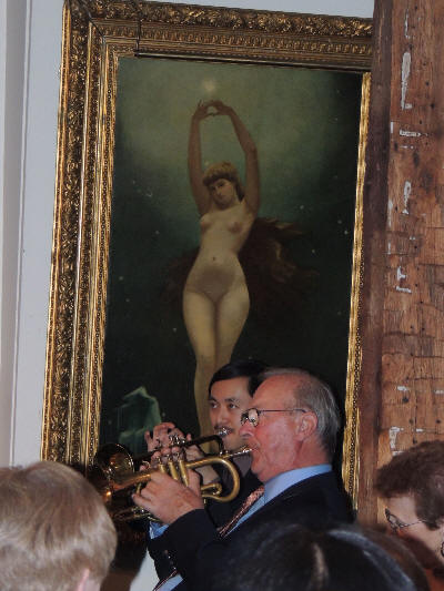 Gordon and Lew sitting playing trumpet, under
			the large picture of a naked lady