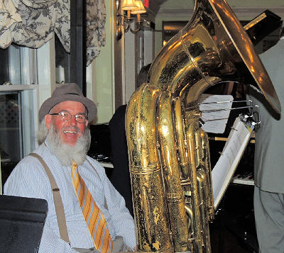 Albie, with his big white beard, smiling behind the tuba