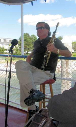 Lee Childs sitting bac, holding sax, looking handsome and content
