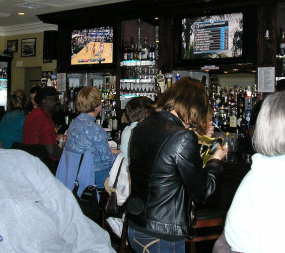 four ladies sitting at fully stocked sports bar