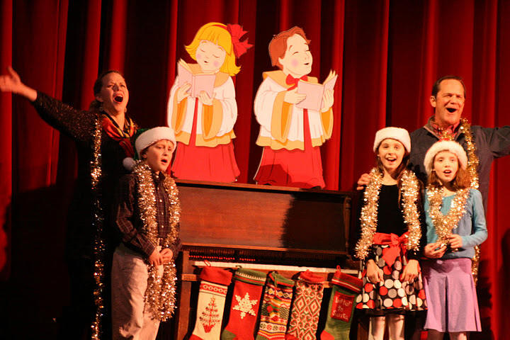 a family at Christmas, hanging stockings on a piano