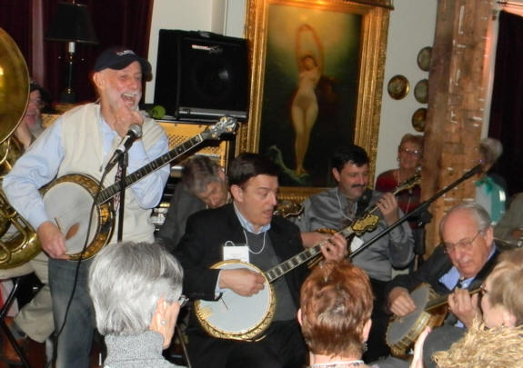 Joel laughing hard with banjos playing beside him. Naked Lady between Vince and Bob