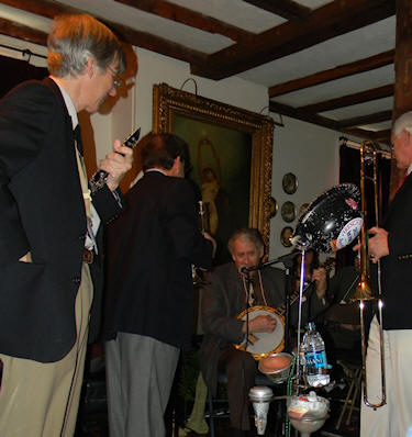 Joe, Fred, and Noel watch Jimmy sing and play banjo