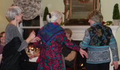 Three happy senior ladies, dressed in bright clothing and dancing