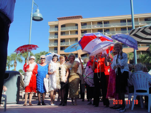 Many flapper ladies with parasols and feather boas